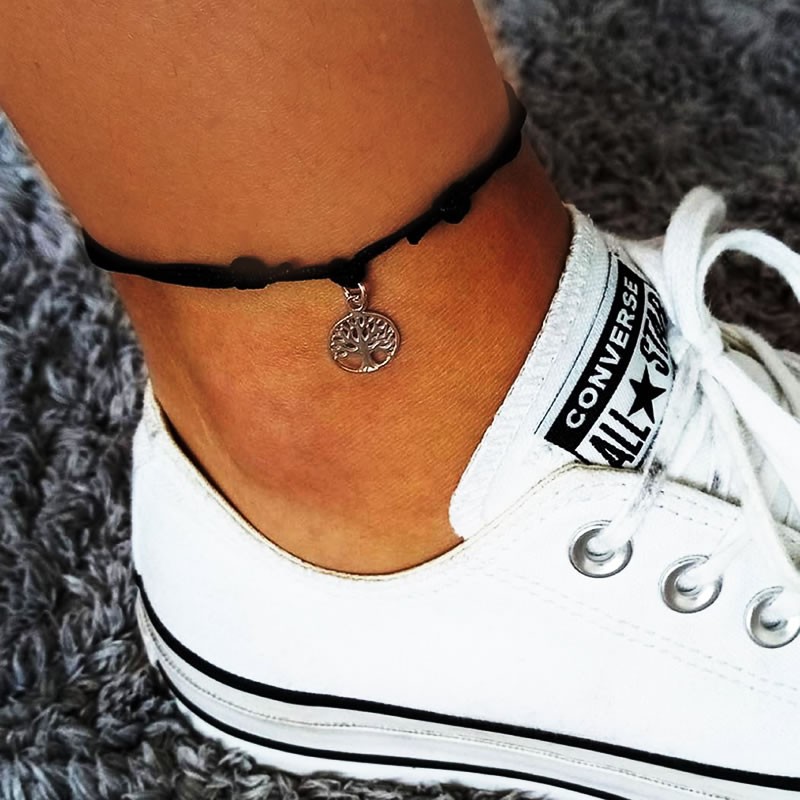 Adjustable thread anklet with a sterling silver charm featuring the Tree of Life symbol.