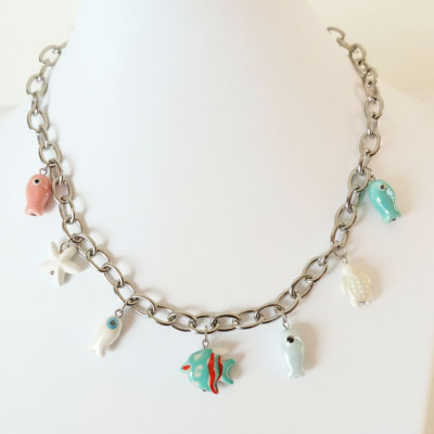 Close-up of the stainless steel necklace with enamelled ceramic marine charms. 2